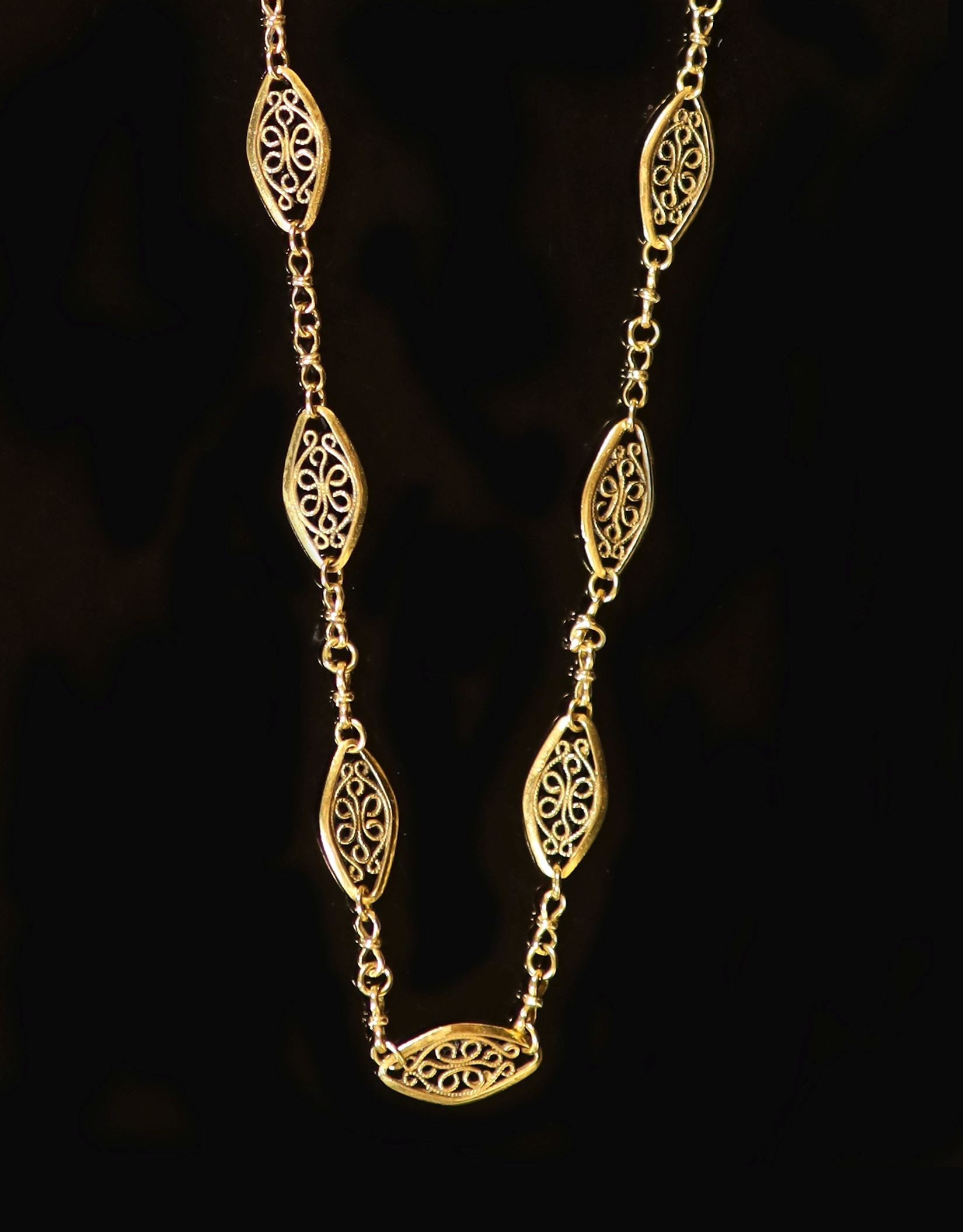 An early 20th century French 18ct gold, pierced navette shaped fancy link long necklace.